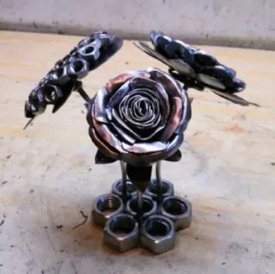 Handcrafted metal rose and butterfly sculptures made from welded nuts and steel, showcasing the artistic side of garage welding.