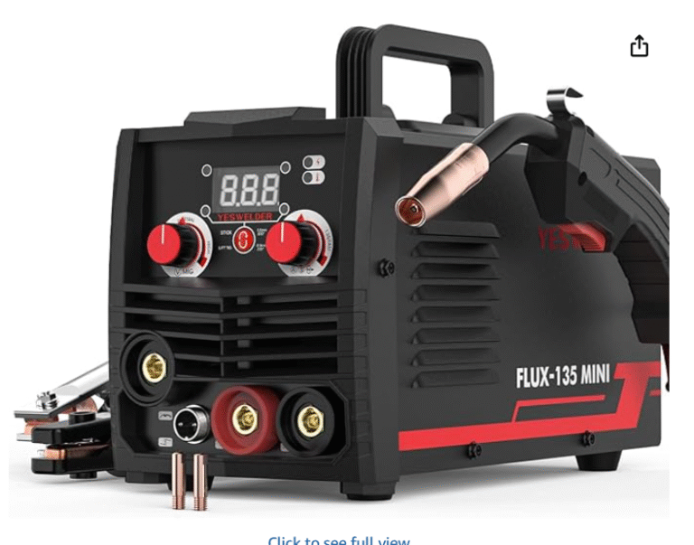 A YESWELDER FLUX-135 MINI welder with red dials and a MIG torch, placed on a scratched wooden workbench in a dimly lit workshop.